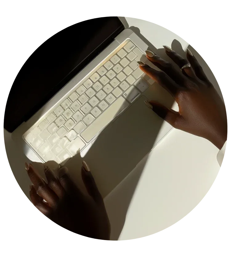 Overhead view of hands typing on a laptop