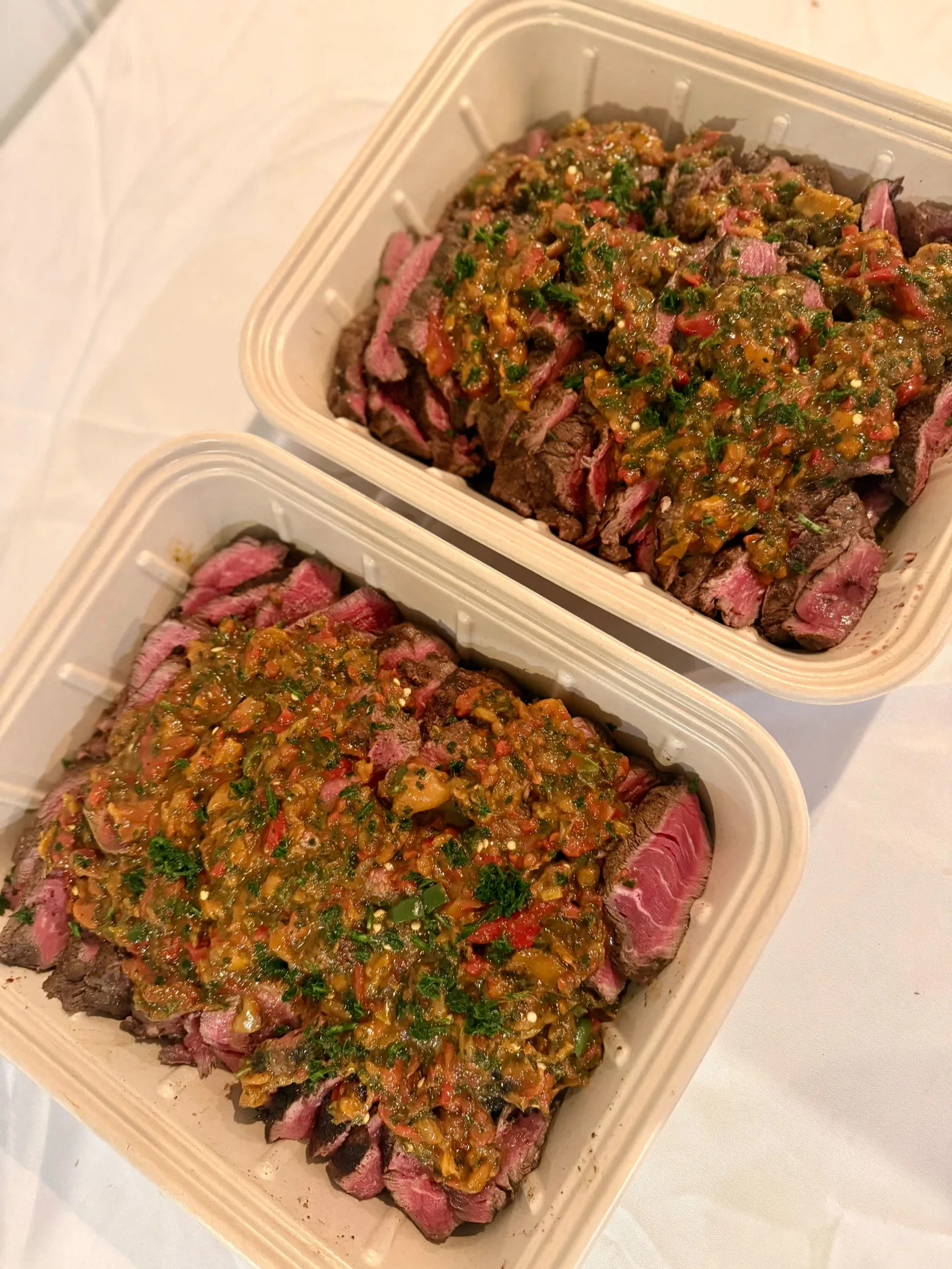 Sliced balsamic steak filet in plant-fiber catering pans