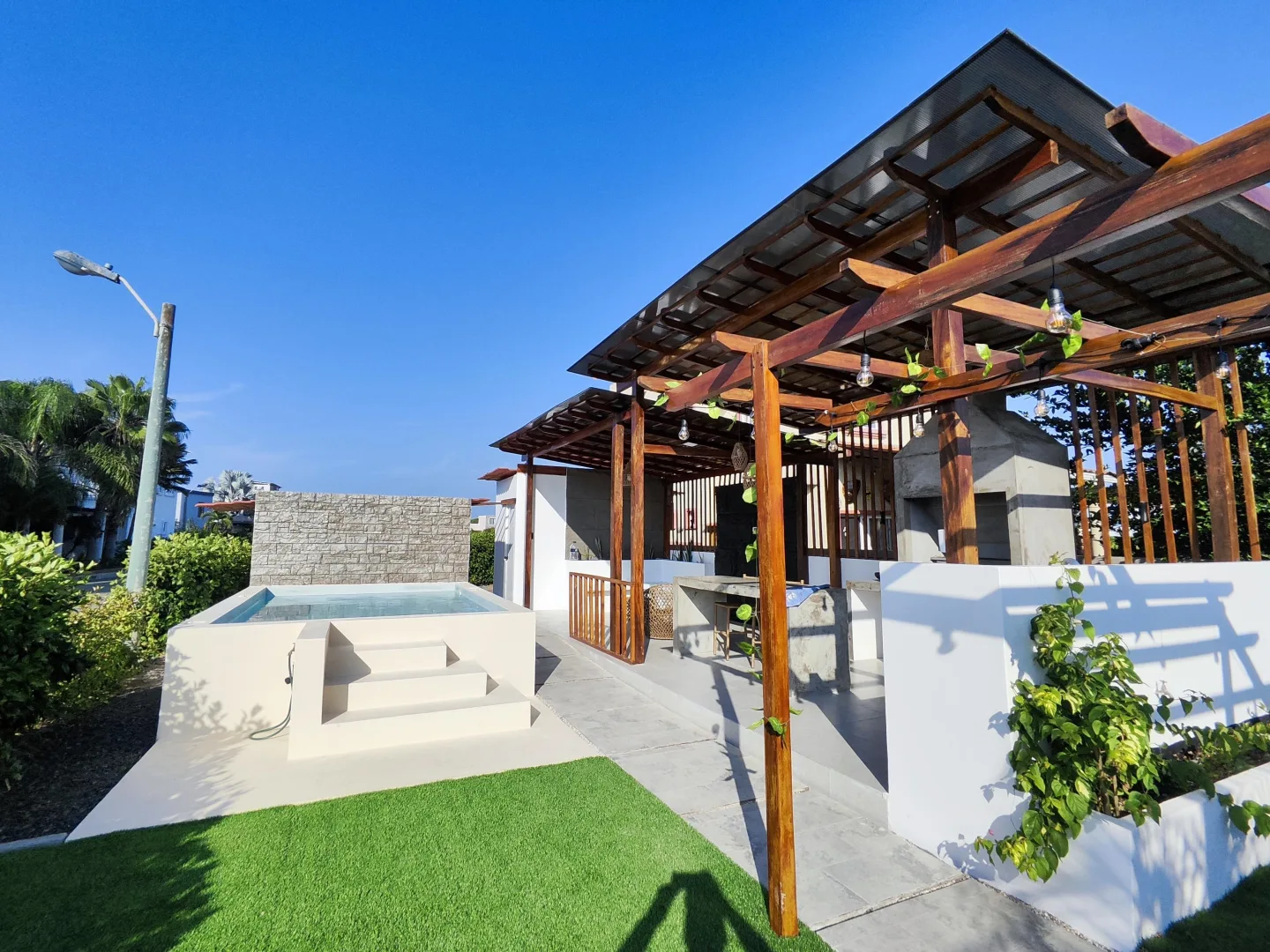 Piscina terminada de NACARK con jardín, pérgola y área social