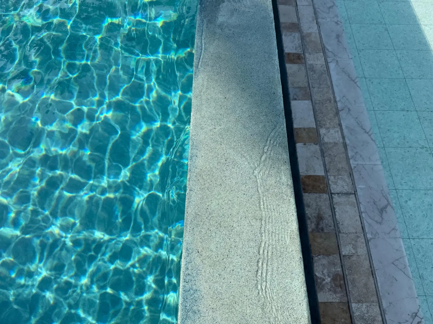 Agua turquesa y mosaico de una piscina terminada por NACARK