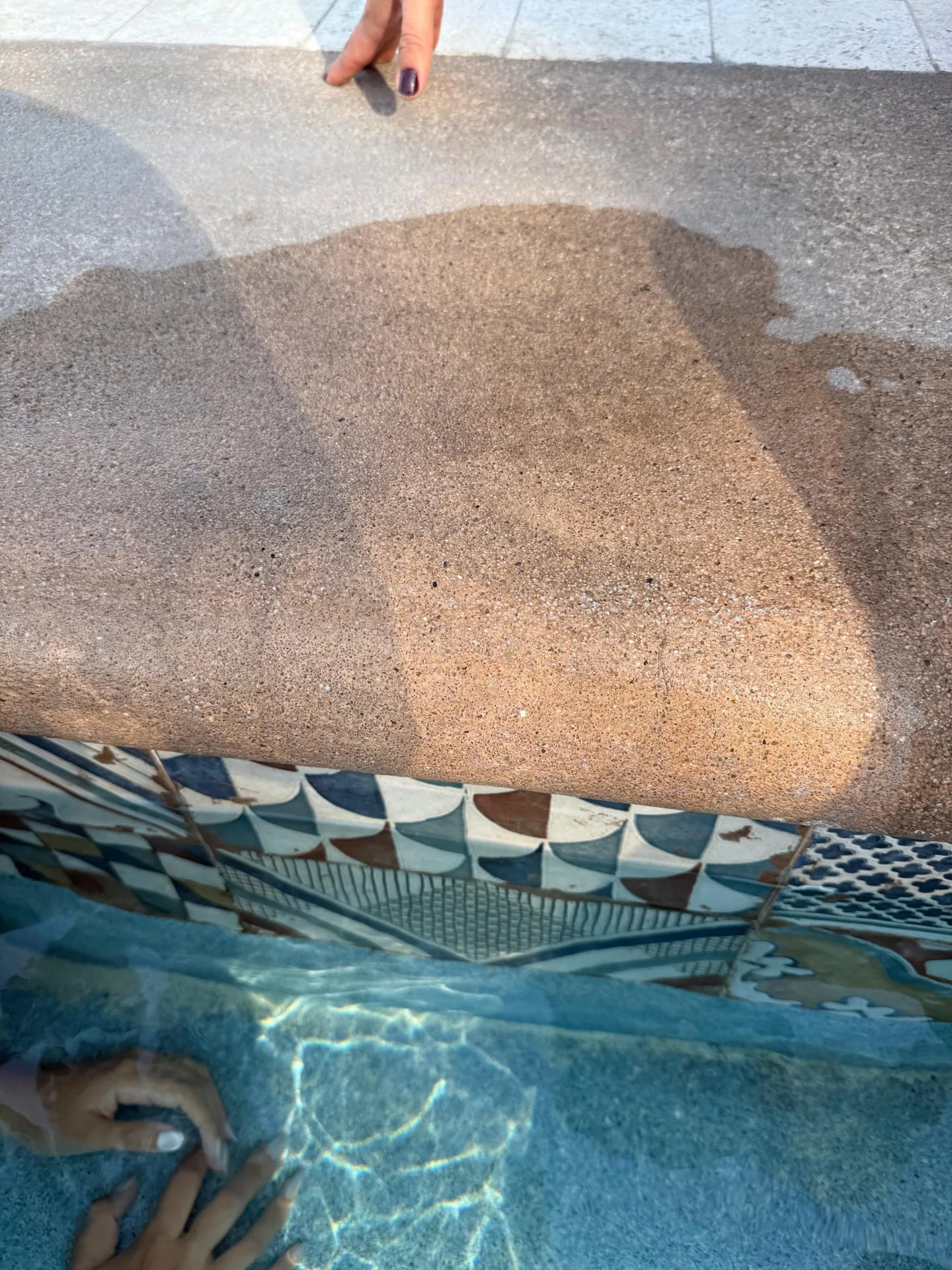 Detalle de acabado y cenefa de mosaico en el perímetro de la piscina