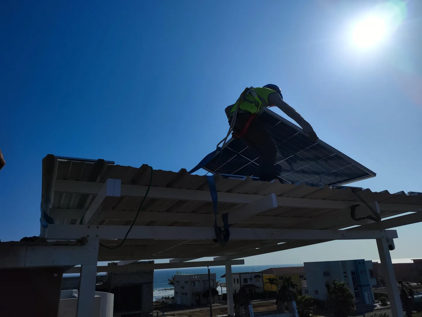 Instalación de paneles solares a contraluz durante un montaje de NACARK en Ecuador