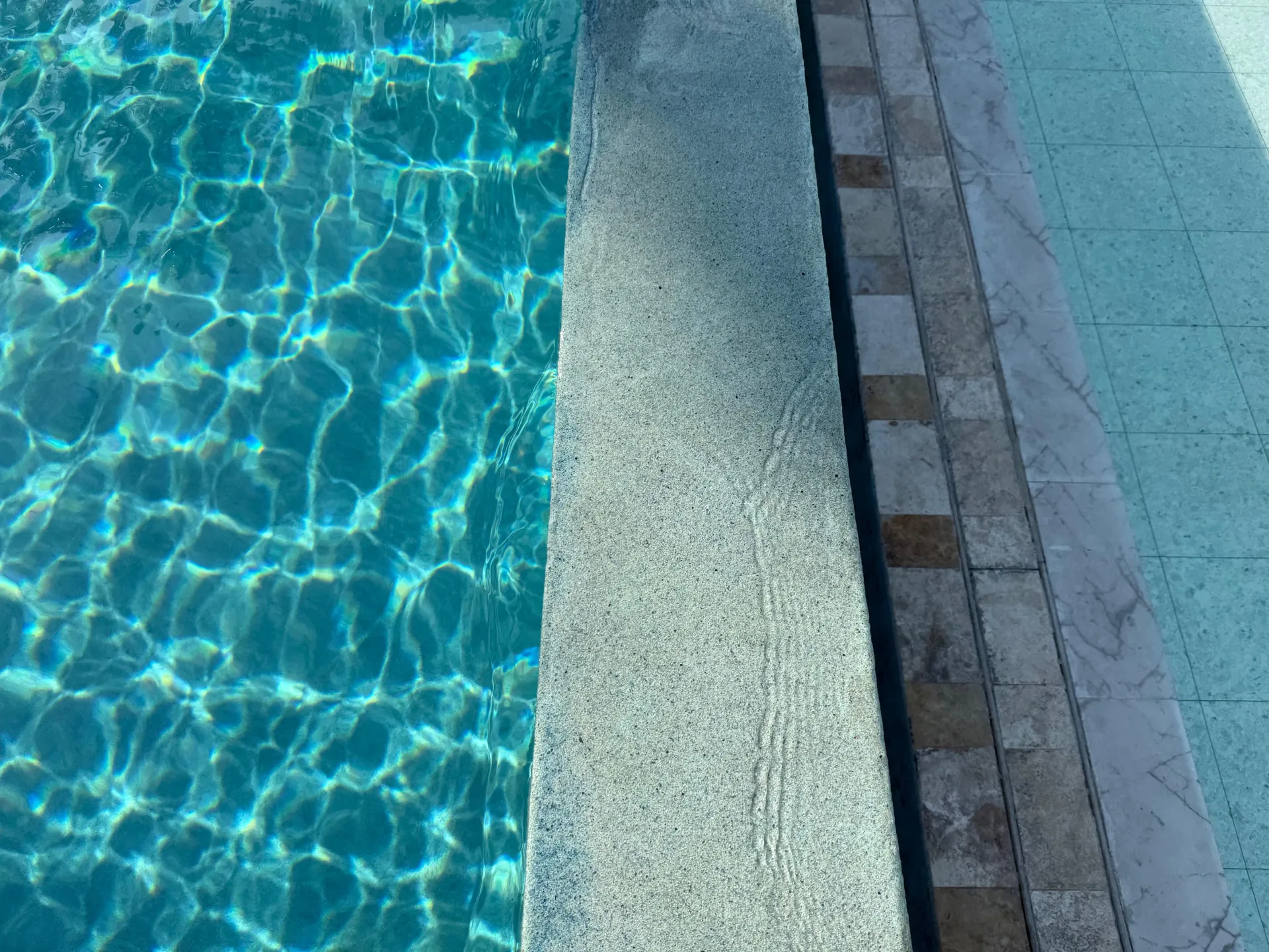 Agua turquesa y acabado de mosaico en una piscina construida por NACARK