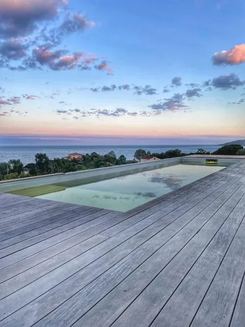 Piscine avec terrasse bois et vue mer