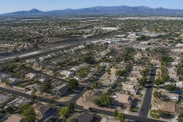 Aerial drone view of residential neighborhoods and road networks in Mesa, AZ under daylight.