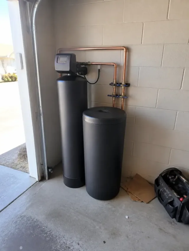 Newly installed salt water softener with copper piping in a residential garage in Mesa, AZ.