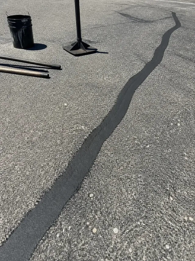 Fresh crack sealing on a weathered asphalt parking lot in Scottsdale, AZ.
