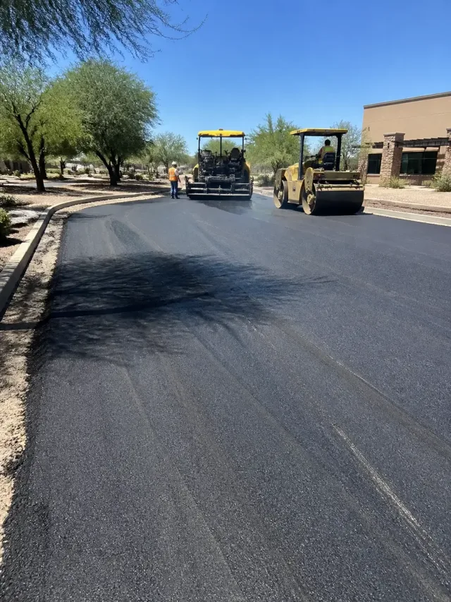 Construction crew paving a retail parking lot with fresh asphalt in Scottsdale, AZ.