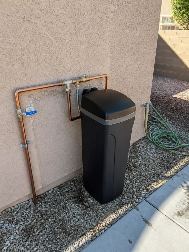 Newly installed saltless water softener connected to exterior plumbing at a home in Mesa, AZ.