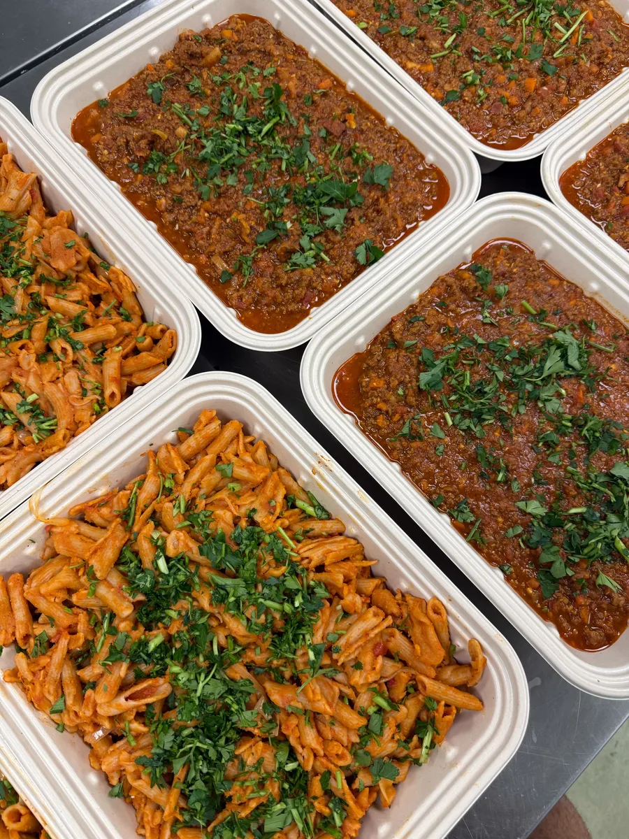 Catering pans of beef bolognese and cassava pasta