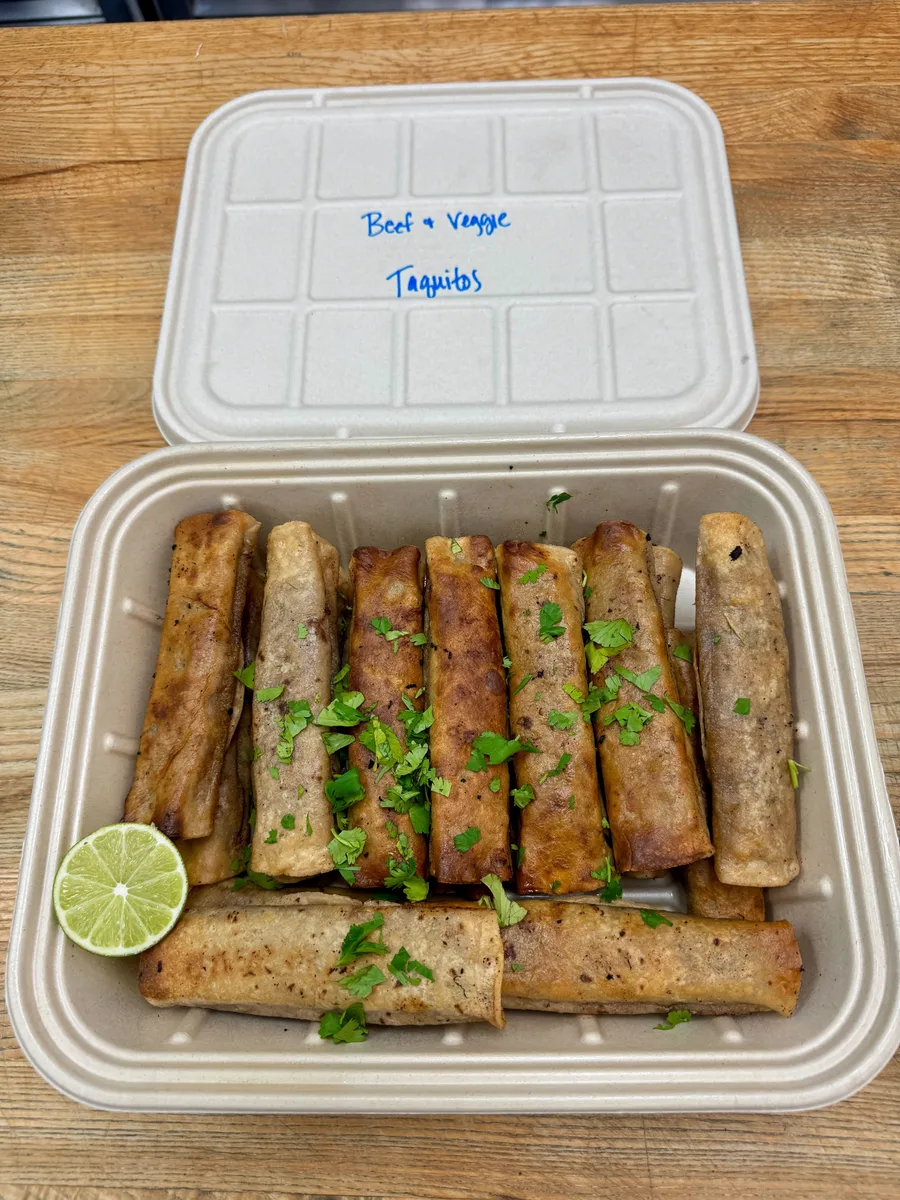 Beef and veggie taquitos in a plant-fiber catering pan