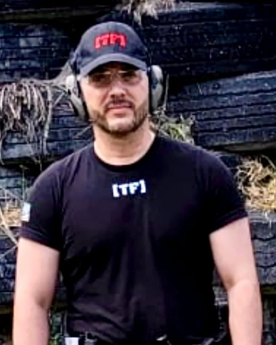 Lemuel Rivera, firearms instructor, at the range in a Tactical Factory cap and shirt