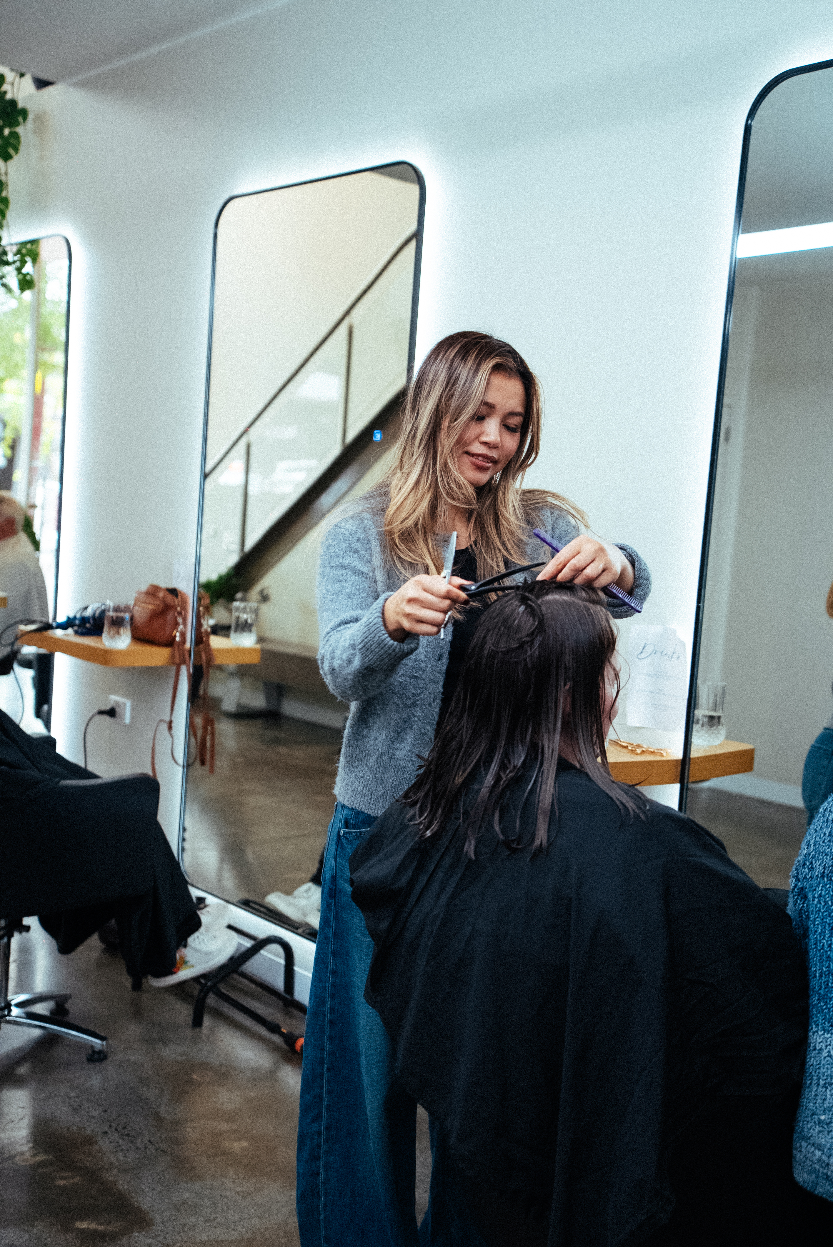 A BIBA Croydon stylist smiling at the mirror