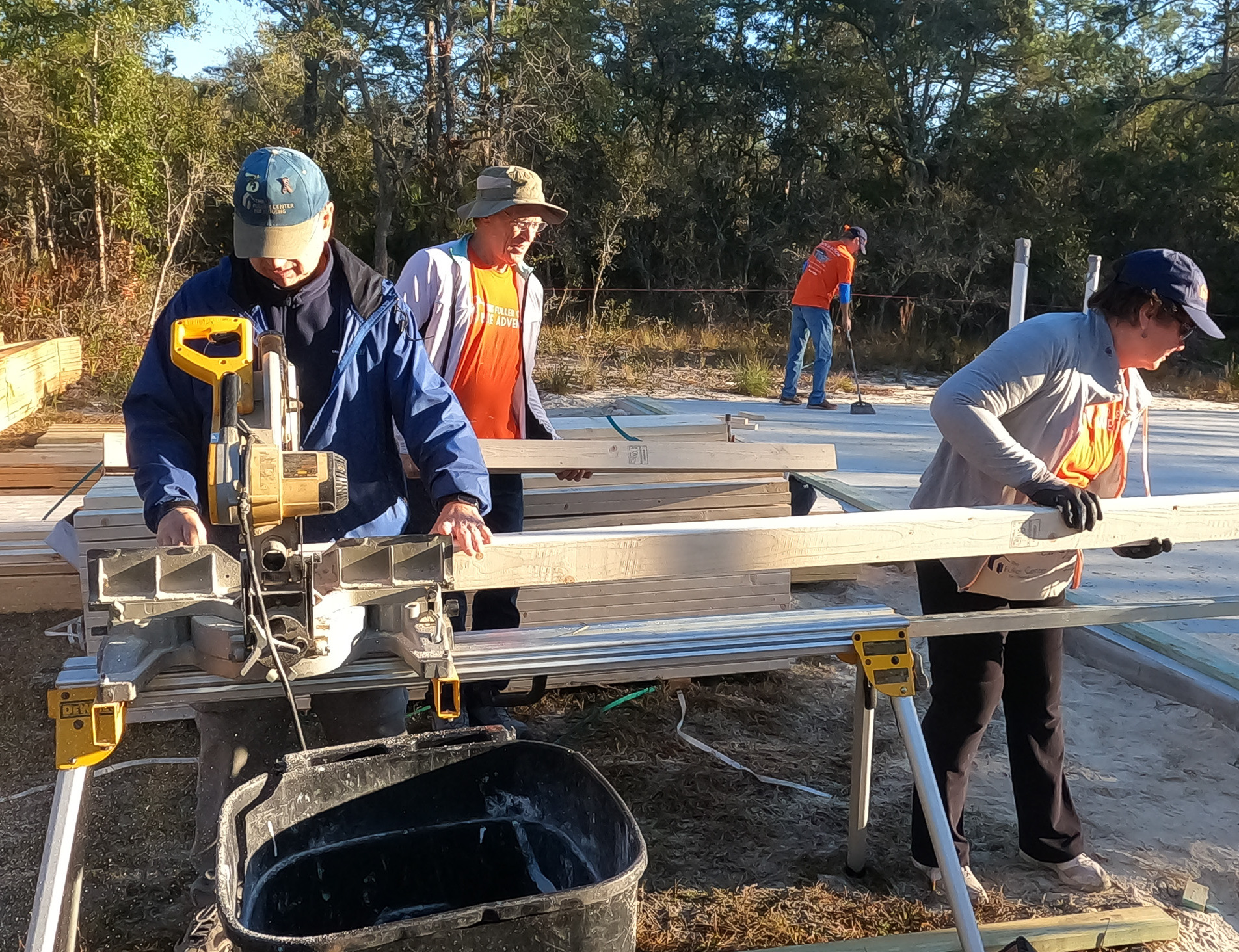 Volunteers from Fuller Center for Housing Delaware working together on home construction, cutting and assembling wood for a repair project.