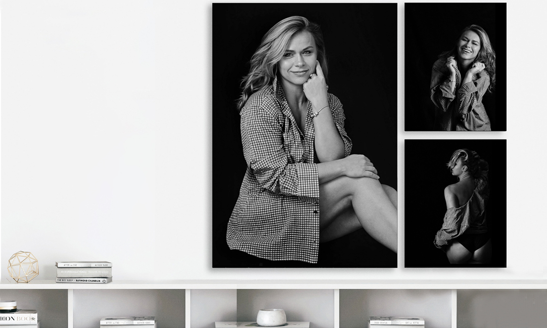 black and white printed photographs of a white happy blond woman on a wall