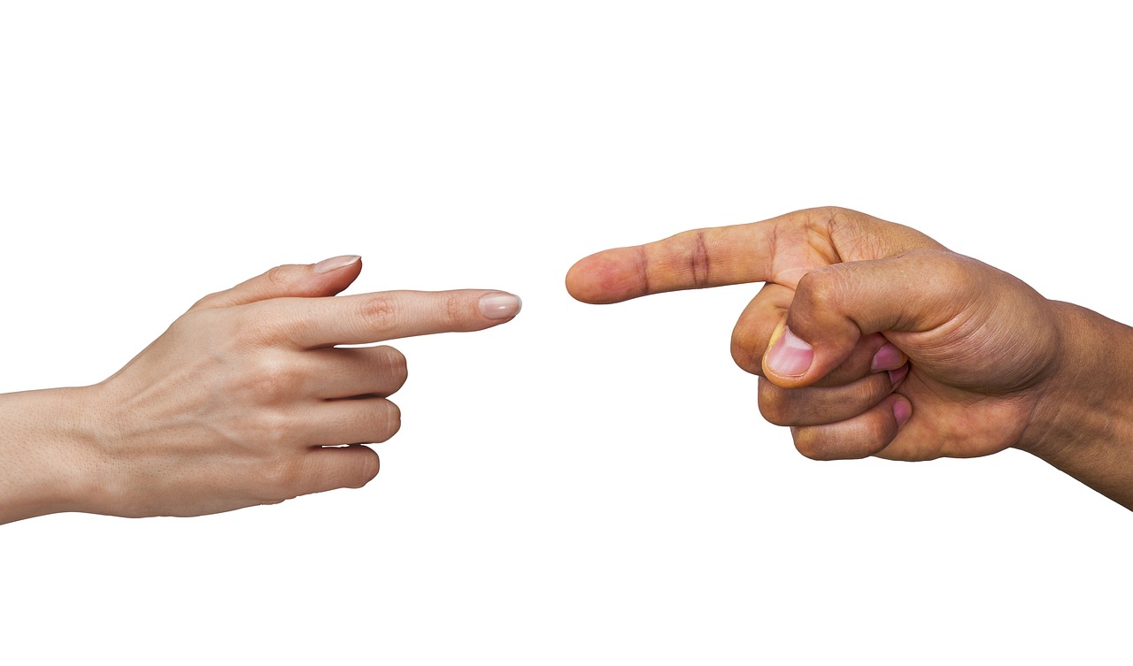 Two hands with fingers pointing at on another