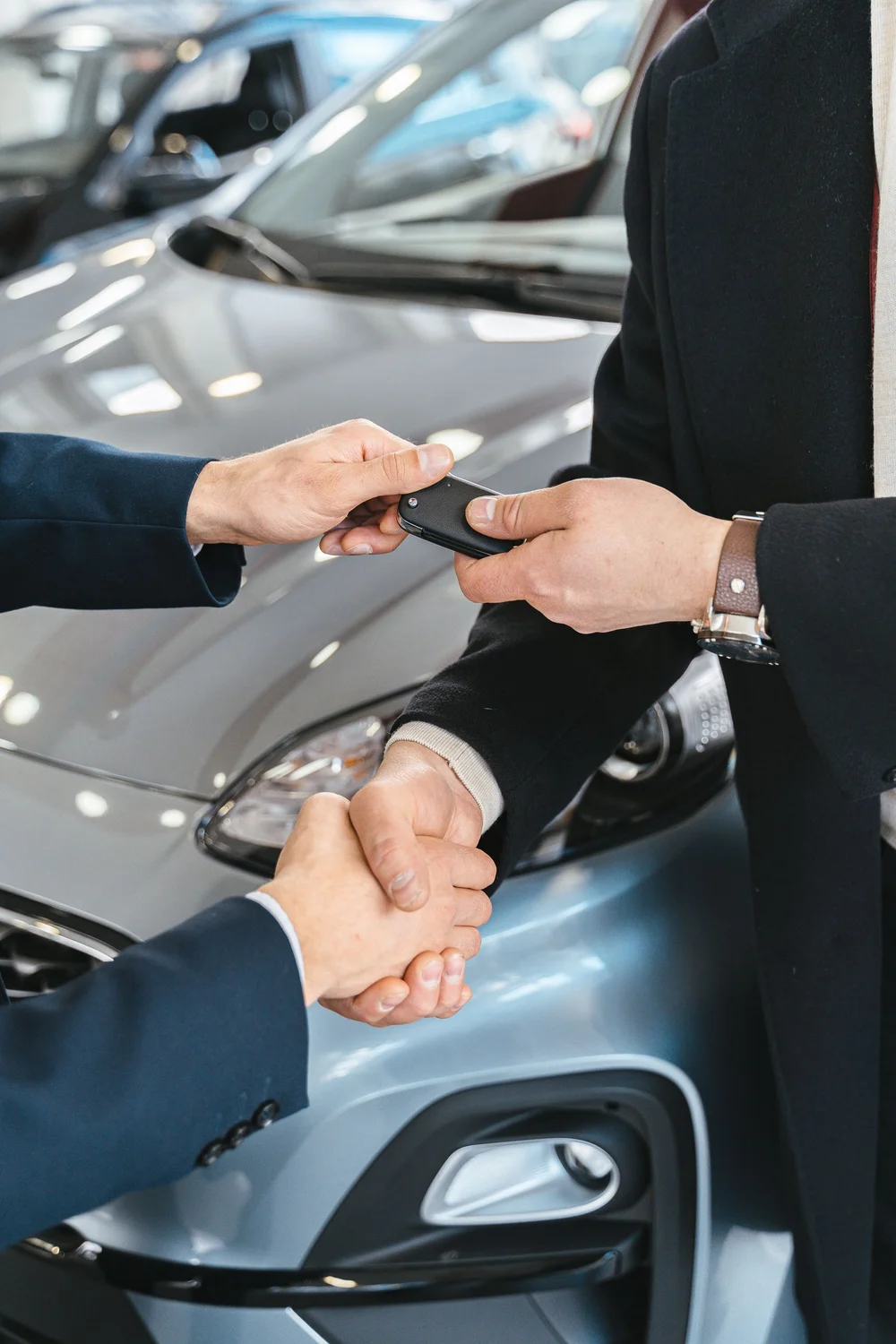 Ein Fahrzeugschlüssel wird im Autohaus übergeben