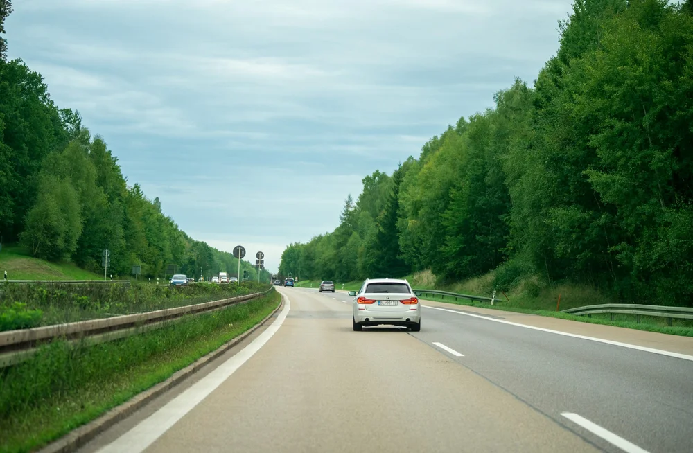 Fahrzeuge auf einer von Bäumen gesäumten deutschen Autobahn