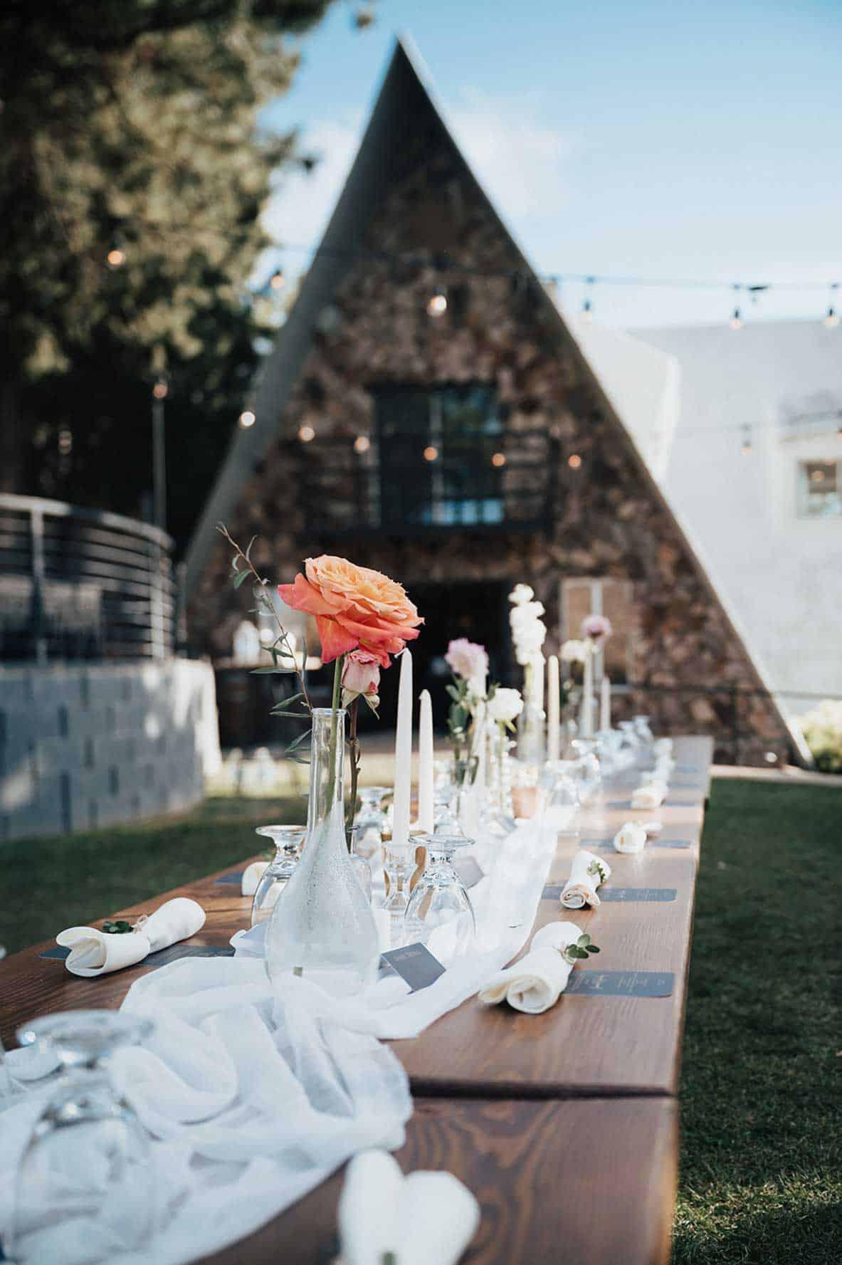 Flowers and glassware on a table with the stone estate in the background
