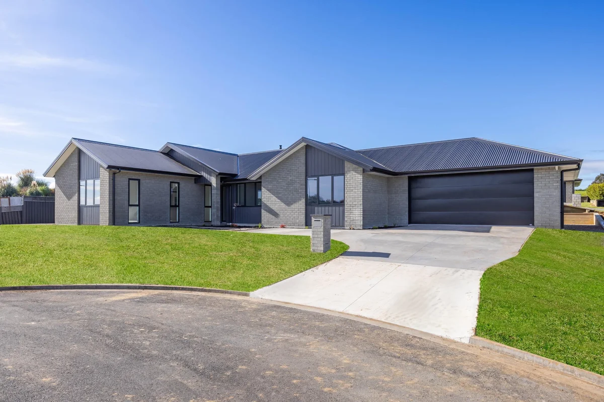 Single-level grey brick home with double garage built by MH Builders at Lot 11, Lotus Place, Te Awamutu
