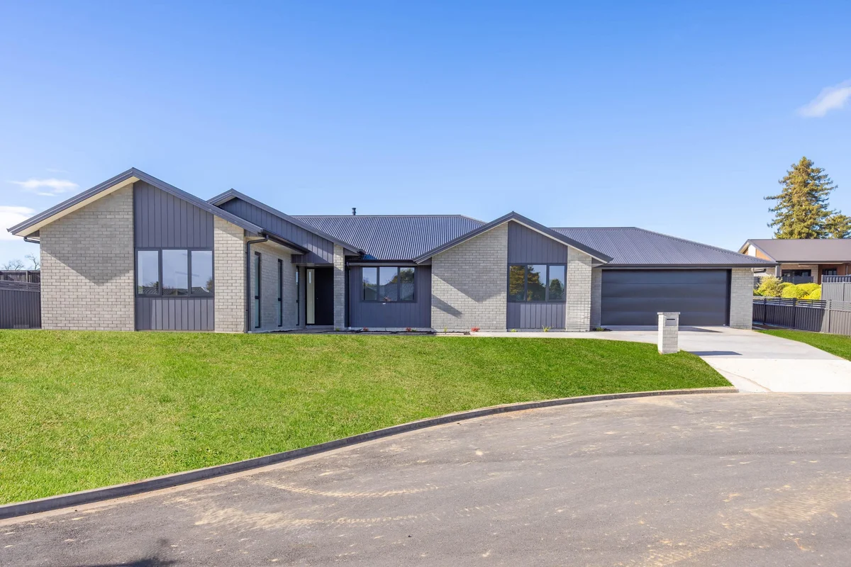 Single-level grey brick home with double garage built by MH Builders at Lot 11, Lotus Place, Te Awamutu