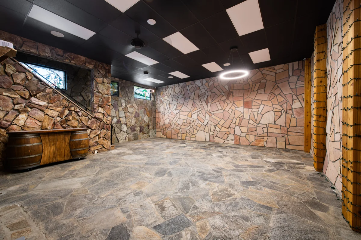 Stone-walled room with a barrel bar and patterned stone floor
