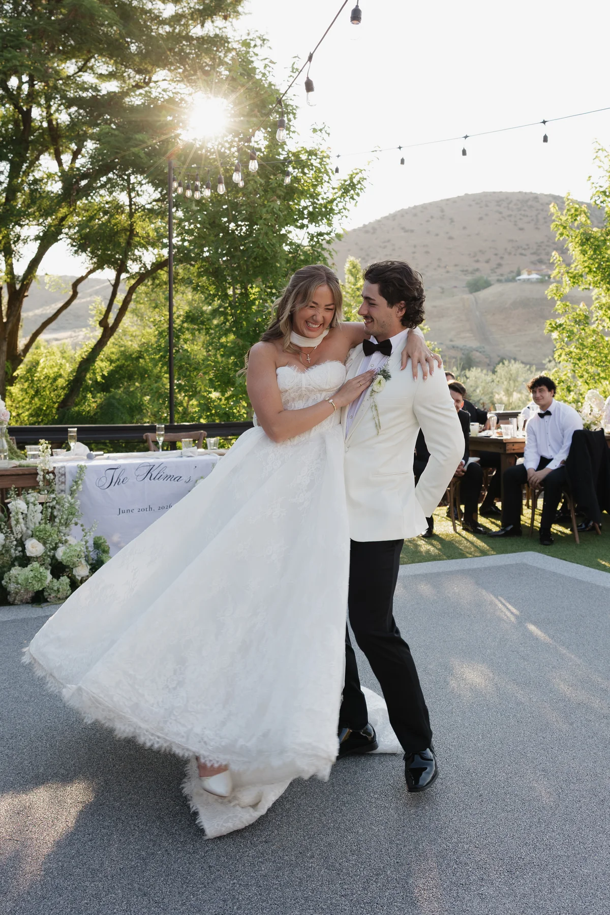 Couple sharing their first dance outdoors beneath string lights