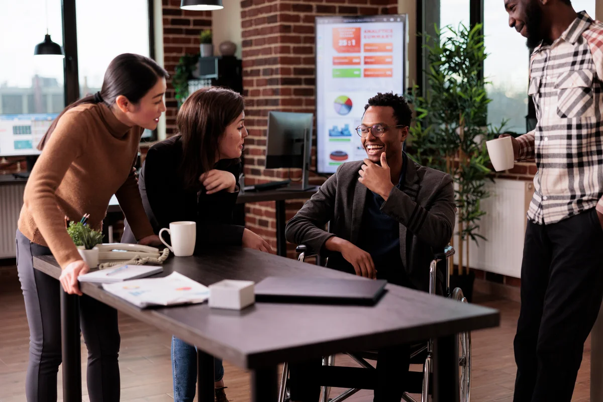 Colleagues talking openly and laughing together around a table