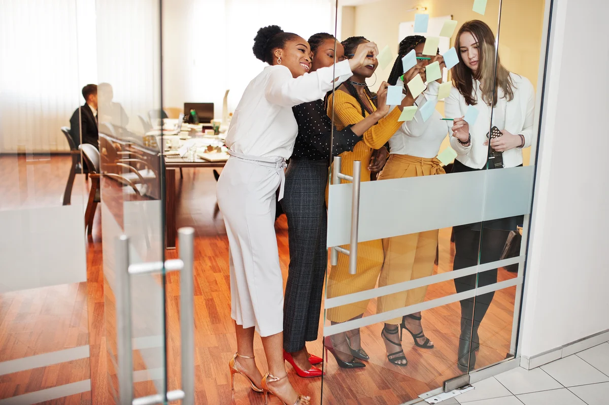  Leaders mapping ideas together on a glass wall