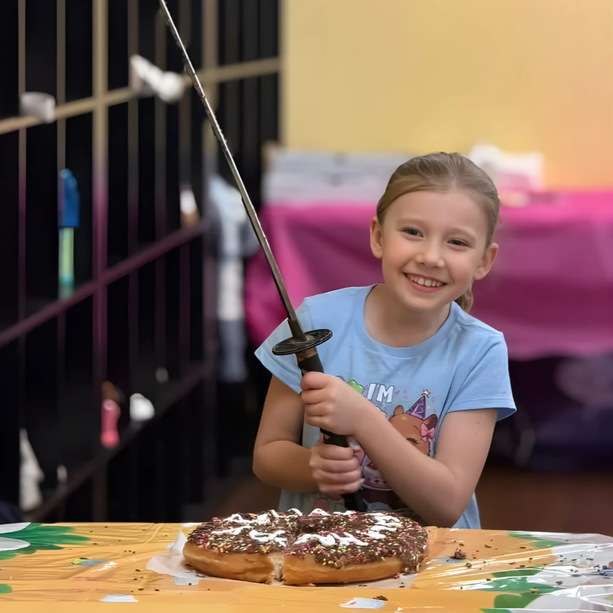 Birthday child cutting her birthday cake with the Mastery samurai sword