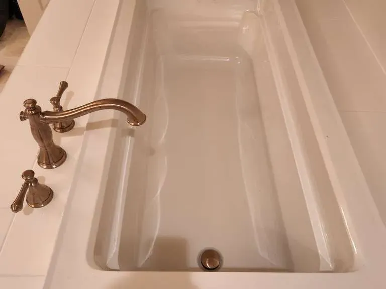 Drop-in soaking tub with bronze fixtures, fully plumbed