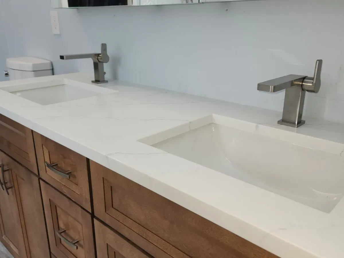 Double-sink quartz vanity install with brushed-nickel faucets