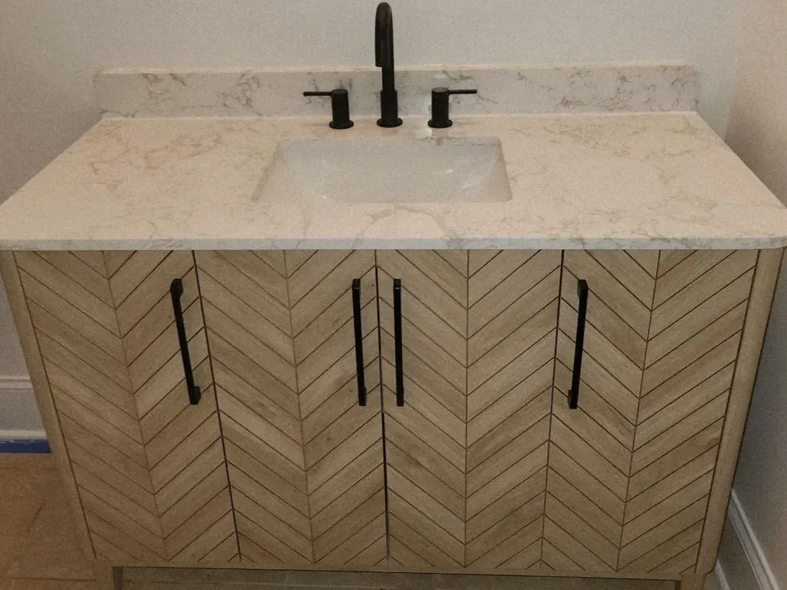 Chevron-front vanity with quartz top and black hardware