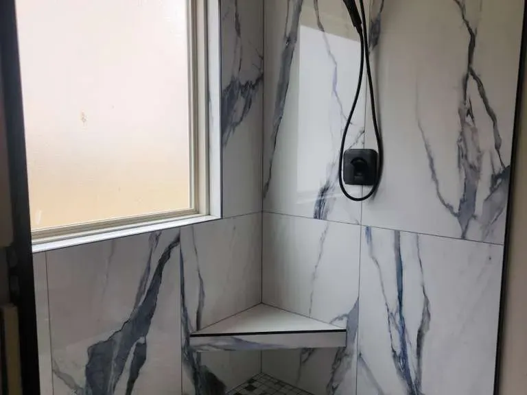 Marble corner shower with bench, brushed-nickel hardware