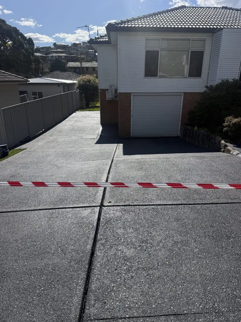 Exposed aggregate driveway after charcoal colour sealing
