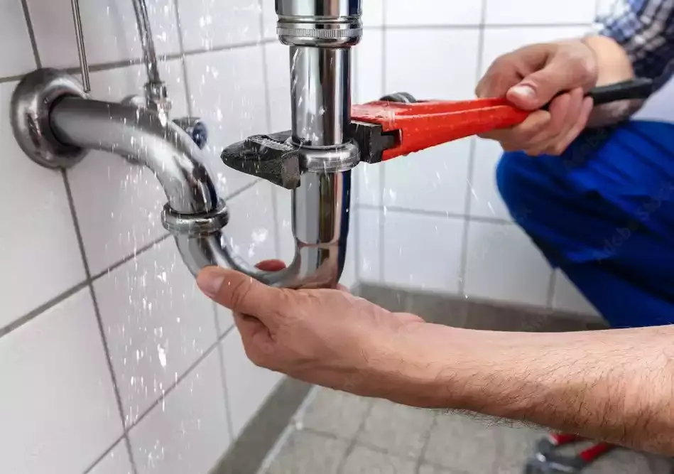 Wrench tightening a sink P-trap during a plumbing repair