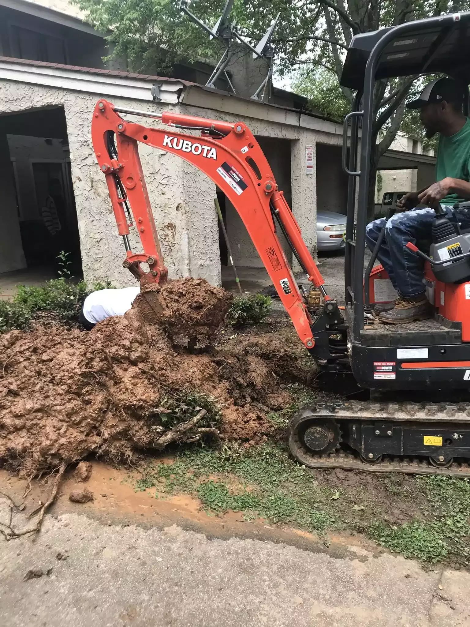 Replacement sewer pipe staged next to an excavator