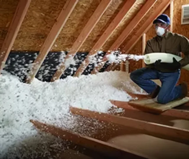 Loose fill insulation being blown into an attic
