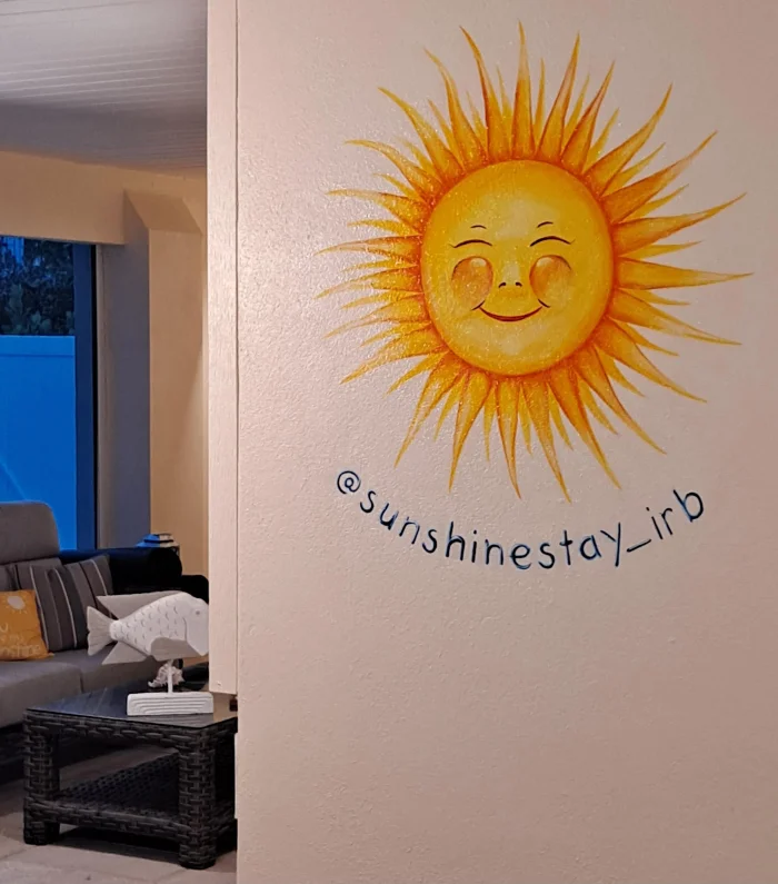 Hand-lettered sun motif painted on an interior wall