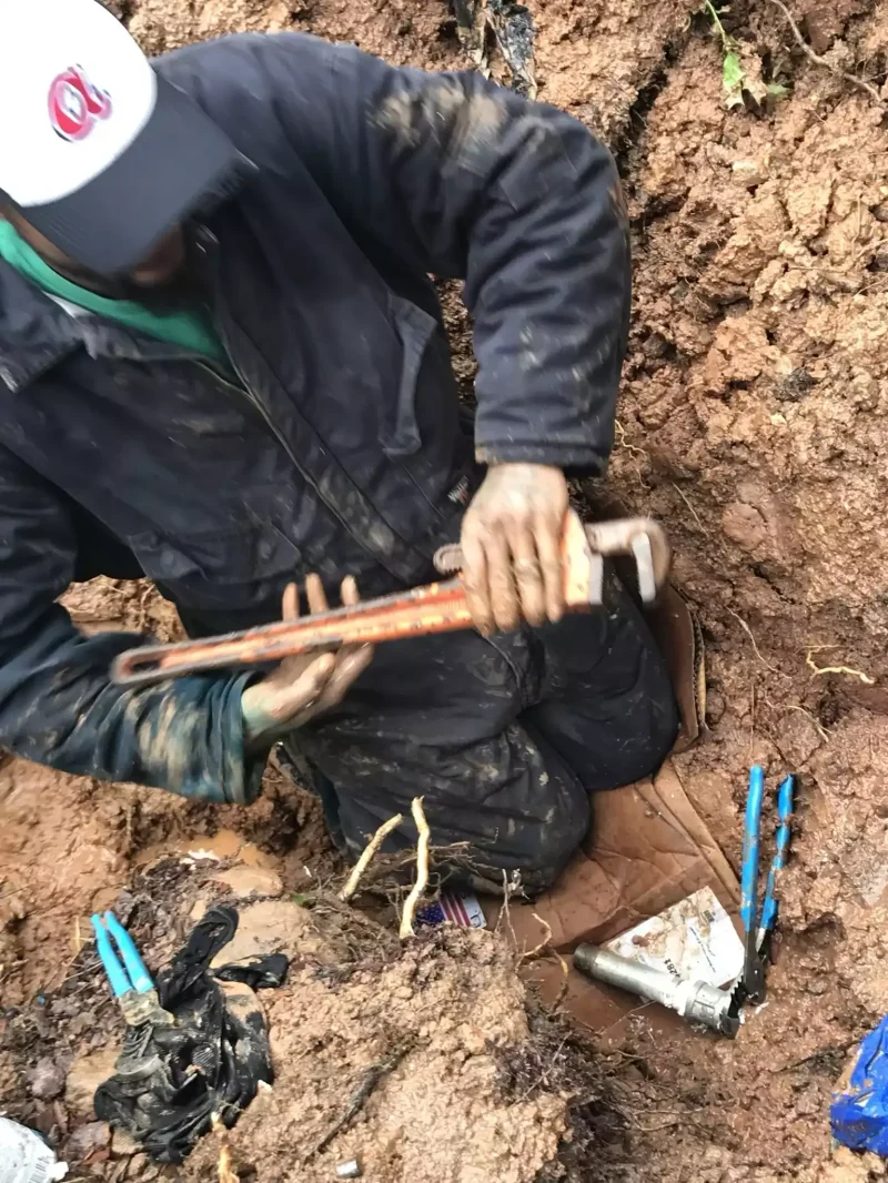 Excavator loading soil during a sewer line dig