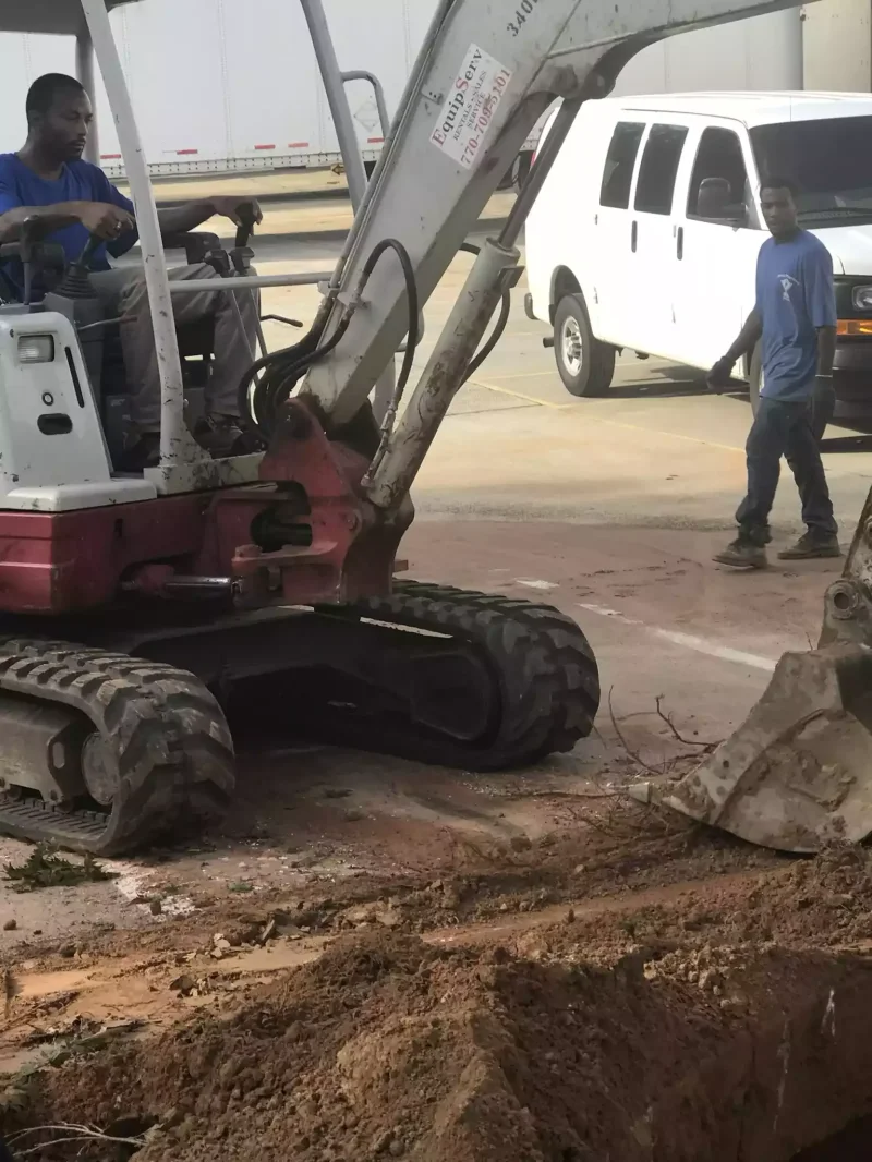 Excavator opening a street cut for a sewer line replacement