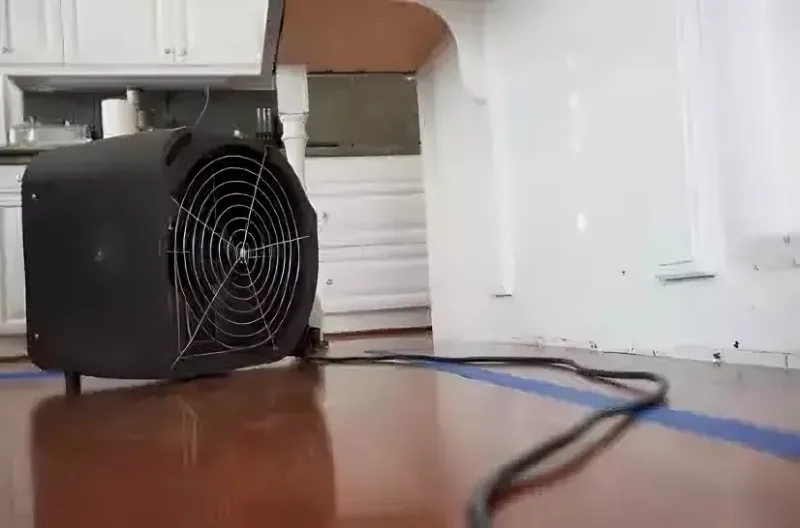 Air mover drying hardwood floors after water damage