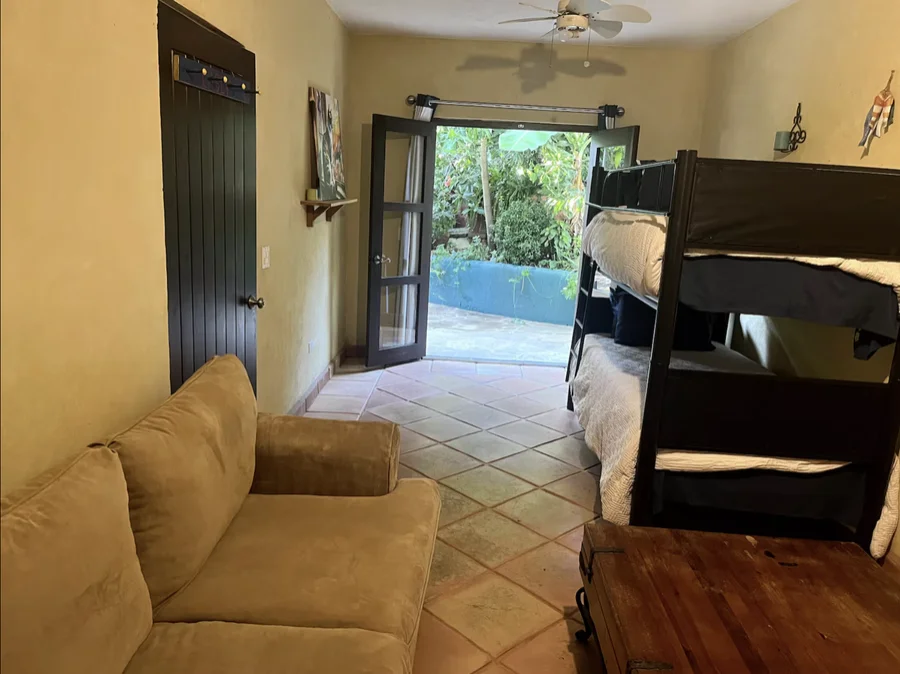 Bunk room at Casa Alba with a couch and doors opening to the garden