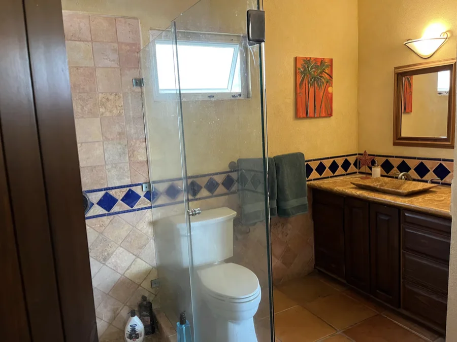 Bathroom at Casa Alba with a glass shower and tiled accent band