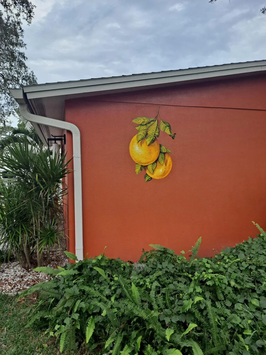 Hand-painted oranges on a terracotta exterior wall