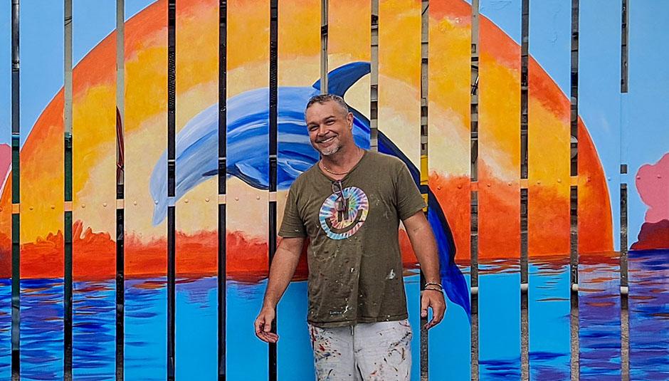 Gary Baillie standing in front of one of his finished murals