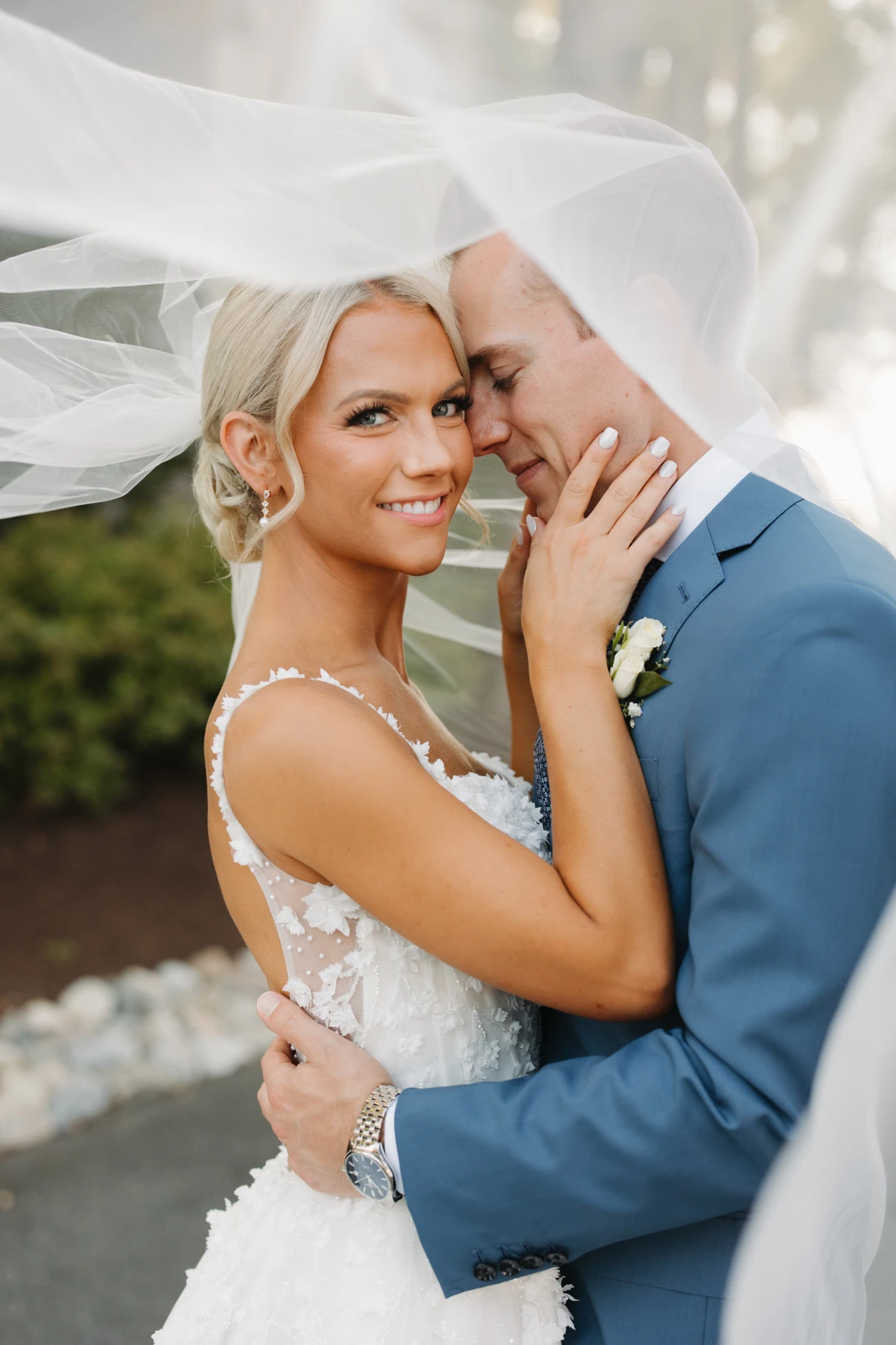 A bride and groom holding each other under her veil