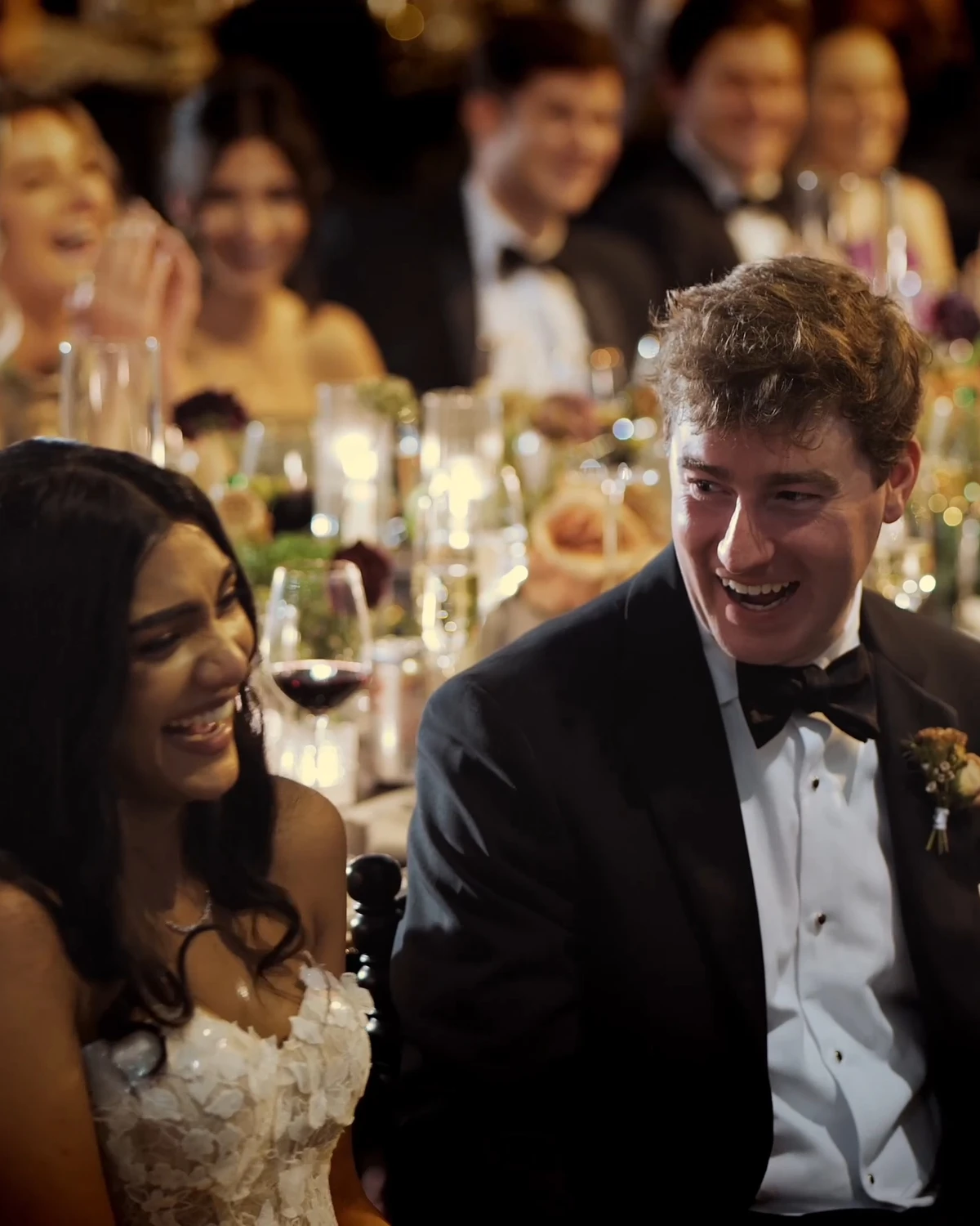 A bride and groom laughing at the head table during the toasts