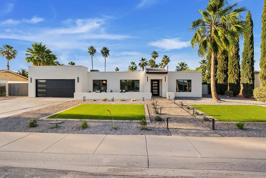Modern white flat-roof home with green turf lawn, paver walkway, and palm trees, AZ Elevate concrete Phoenix