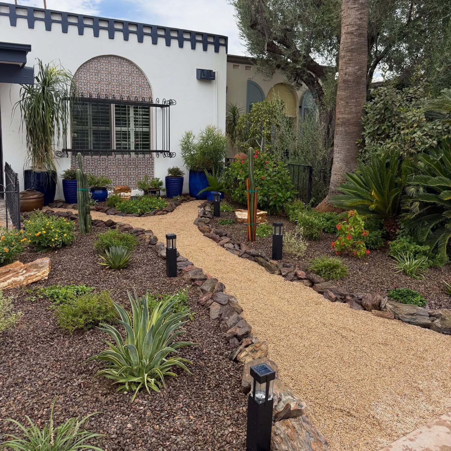 Desert front yard with curving DG path, agave, cacti, blue accent pots and white stucco home, AZ Elevate landscaping Phoenix